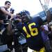 Michigan senior quarterback Denard Robinson smiles as he high-fives fans while making his way off the field and up the tunnel after beating UMass 63-12 at Michigan Stadium on Saturday. Melanie Maxwell I AnnArbor.com